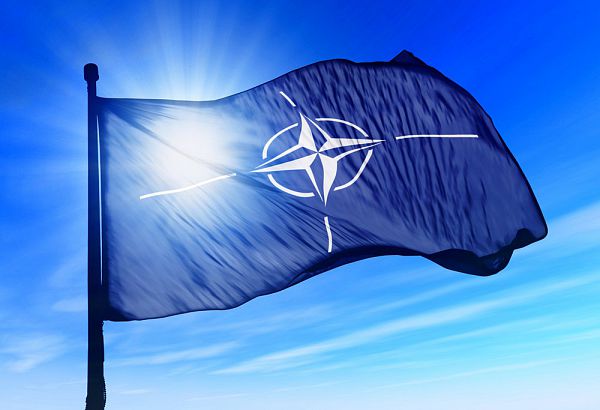 NATO flag waving over the sky 